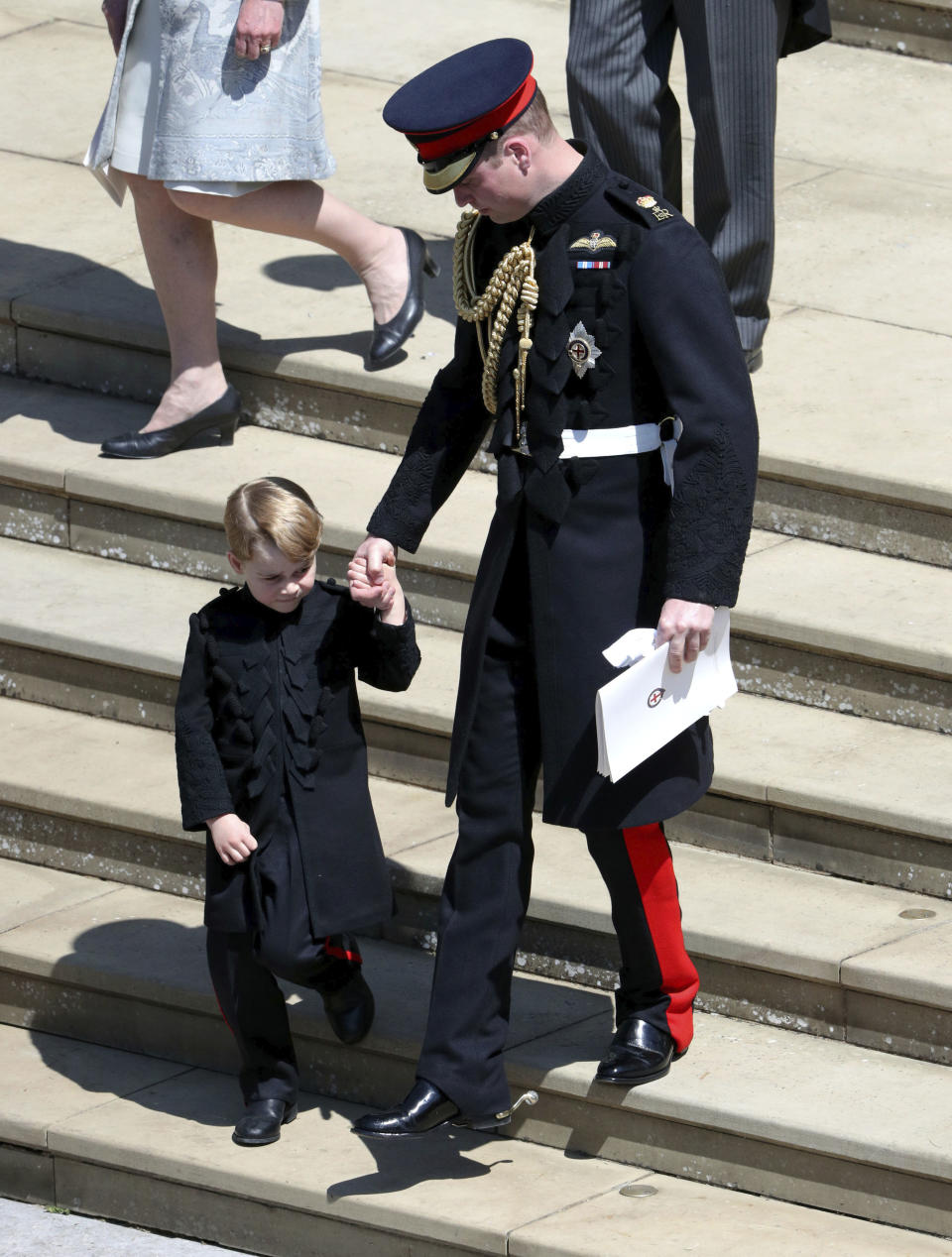 Prince George held hands with his dad, Prince William, when they exited the church. Photo: AAP