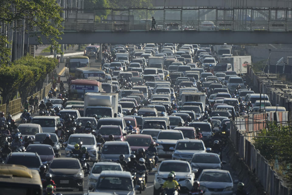 A man walks over rush hour traffic during a transport strike in Quezon city, Philippines on Monday, March 6, 2023. Philippine transport groups launched a nationwide strike Monday to protest a government program drivers fear would phase out traditional jeepneys, which have become a cultural icon, and other aging public transport vehicles. (AP Photo/Aaron Favila)