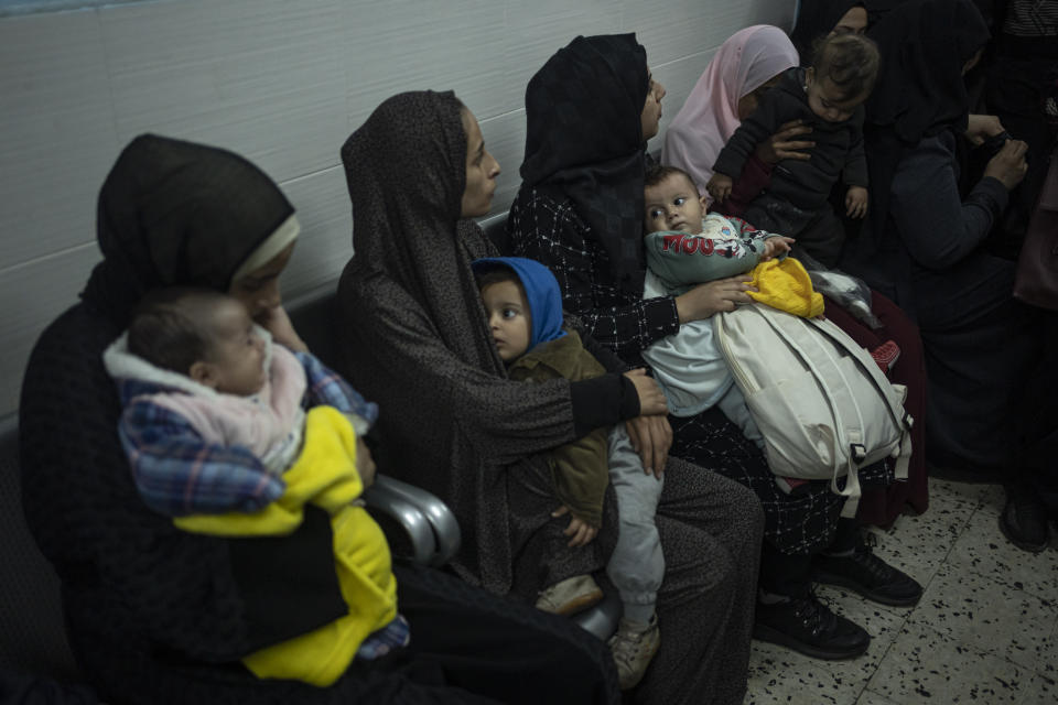 Palestinians line up with their children to receive vaccination against diseases, which recently entered Gaza as part of aid, in Rafah, southern Gaza Strip, Tuesday, Jan. 2, 2024. The vaccination was not available due to the war and most children are about 3 months late for their vaccination. (AP Photo/Fatima Shbair)