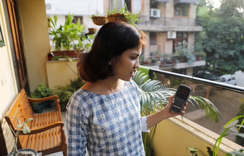 Nabeela Moinuddin uses an air quality monitor device to check the pollution level in her house in New Delhi