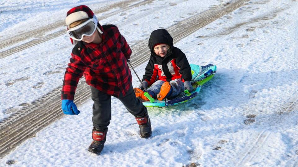Levi Davis, 4, pulls Uriah Davis, 3, up a snow-covered driveway near Parkhill Road Feb. 23, 2023, as a frigid winter storm swept through San Luis Obispo County.