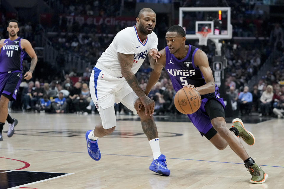 Sacramento Kings guard De'Aaron Fox, right, drives against Los Angeles Clippers forward P.J. Tucker during the first half of an NBA basketball game, Sunday, Feb. 25, 2024, in Los Angeles. (AP Photo/Ryan Sun)