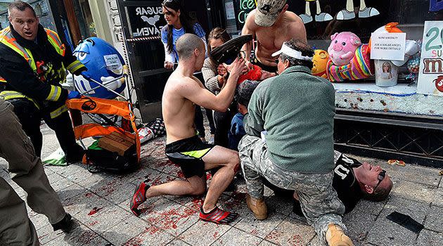 Bystanders tend to an injured man following explosions at the Boston  Marathon. Photo: Reuters