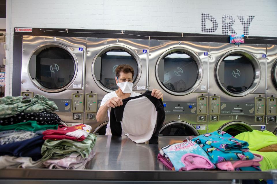 Elizabeth Fitzsimmons, attendant, folds a client's laundry at Washing Well in Aberdeen Twp., NJ Tuesday May 9, 2023.