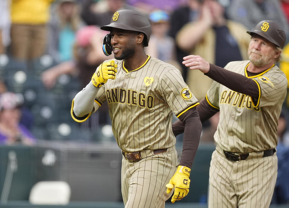 San Diego Padres' Jurickson Profar, left, is guided toward home plate by third base coach Tim Leiper as Profar circles the bases after hitting a two-run home run off Colorado Rockies relief pitcher Nick Mears in the seventh inning of a baseball game Thursday, April 25, 2024, in Denver. (AP Photo/David Zalubowski)