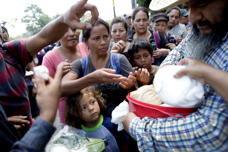 Migrants, mainly from Central America and marching in a caravan, gather to receive food, near Frontera Hidalgo, Chiapas