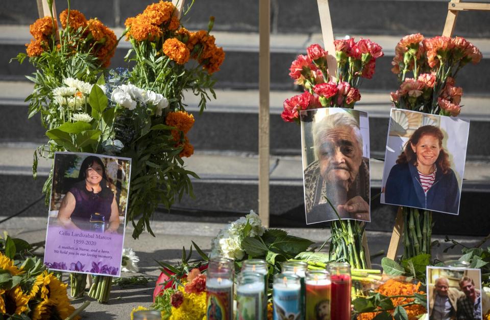 Photos of people who died in the pandemic, including Celia Marcos, left, are part of a memorial in downtown Los Angeles