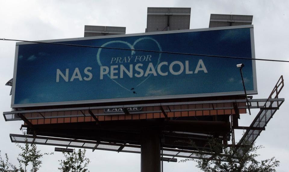 A Pray for NAS Pensacola billboard is over downtown Pensacola 