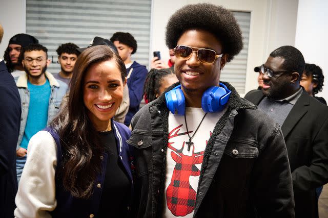 <p>Lee Morgan for The Archewell Foundation</p> The Duke and Duchess of Sussex posed for photos with fellows at The Marcy Lab school as the visit came to a close. Here, Meghan shares a smile with Jumaane Royster.