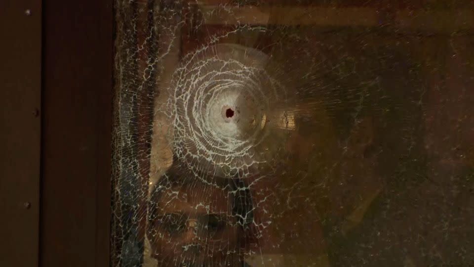 A bullet hole can be seen in the glass of one of the school's doors. - CBC