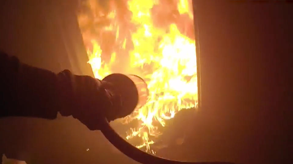 A prison guard attempting to put out a fire with an extinguisher at Mary Wade Correctional Centre.