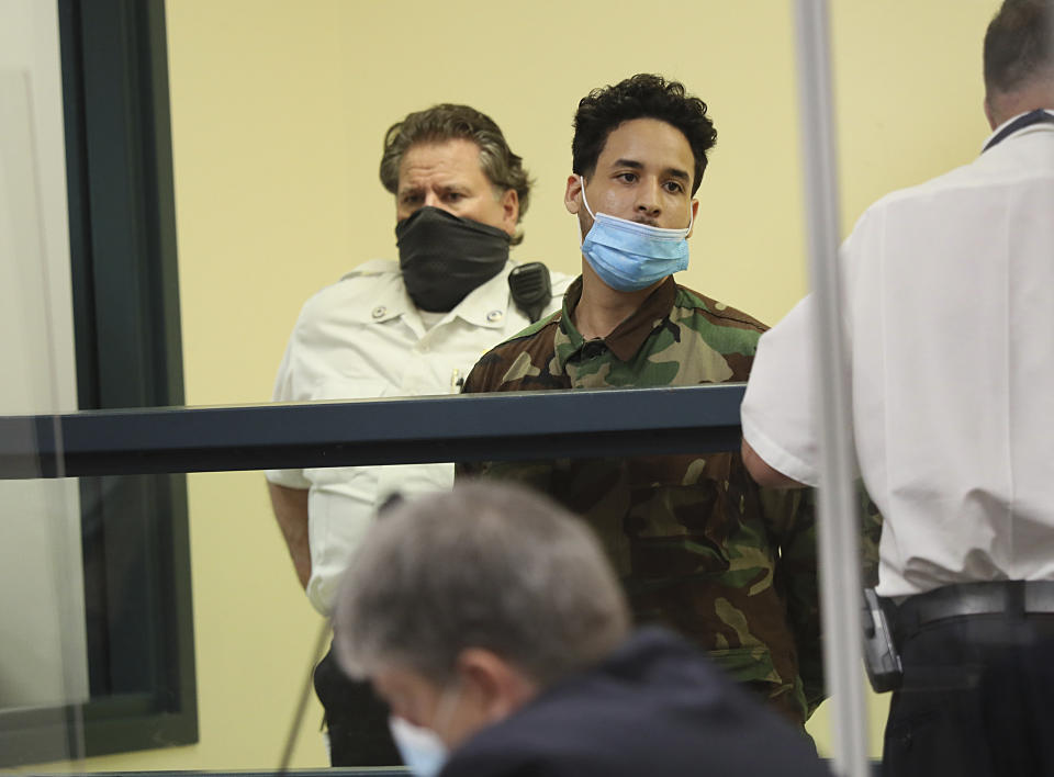 Robert Rodriquez, center, one of 11 people charged in connection with an armed standoff along a Massachusetts highway last weekend, appears during his arraignment at Malden District Court, Tuesday, July 6, 2021, in Medford, Mass. (Suzanne Kreiter/The Boston Globe via AP, Pool)