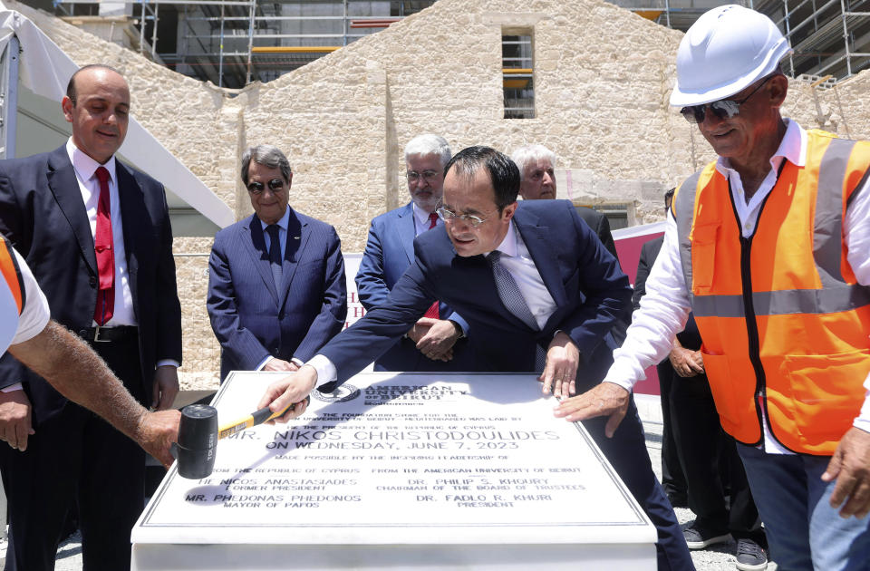 In this photo provided by Cyprus Press and Information Office, Cyprus President Nicos Christodoulides, second right, former Cyprus' President Nikos Anastasiades, second left, and President of AUB, Fadlo R. Khuri, left, stand around a plaque, near to the American University of Beirut building under construction, in the western coastal city of Paphos, Cyprus, Wednesday, June 7, 2023. Cyprus bested 15 other countries as the most suitable to host the American University of Beirut's first overseas campus, the president of the world-renowned institution said. (Stavros Ioannides /Cyprus Press and Information Office via AP)