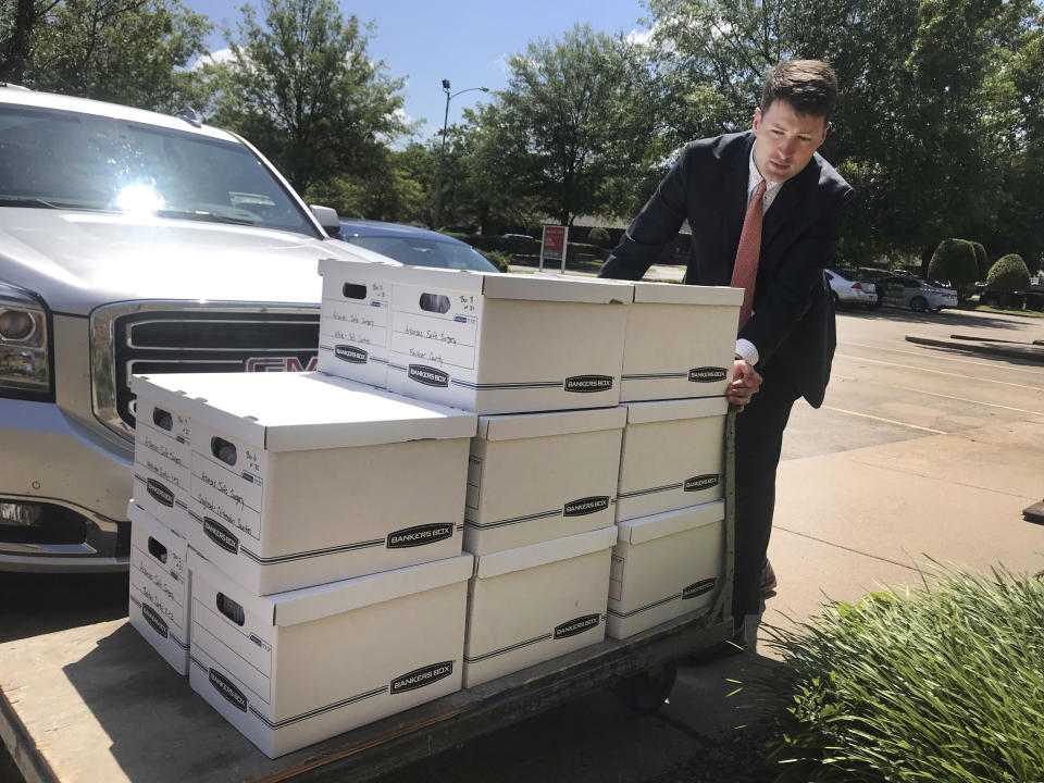 FILE - In this July 23, 2019, photo, Alex Gray, an attorney for Safe Surgery Arkansas, delivers petitions to the Arkansas secretary of state's office in favor of holding a referendum on a state law that expands the type of procedures optometrists can perform in Little Rock, Ark. Arkansas election officials on Friday, Aug. 2, 2019, rejected the attempt to hold a referendum next year on a new state law expanding what procedures optometrists can perform that has sparked an unusually expensive and public lobbying fight. (AP Photo/Andrew DeMillo, File)