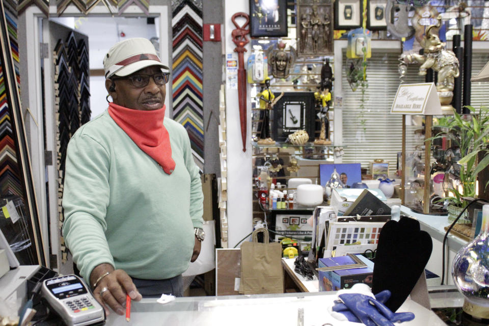 Jerome Polk stands behind the counter of his business, J.P's Custom Framing, on Wednesday, July 1, 2020, as he discusses protests that have been unfolding nightly in a historically Black neighborhood in Portland, Ore. Polk has owned his business for 26 years and rents space in a building that also is home to the Portland Police Bureau's North Precinct, which has been targeted recently by demonstrators. Polk worries that some protesters' tactics, such as setting fires and vandalizing businesses, are distracting from the Black Lives Matter message of racial equality and police accountability. (AP Photo/Gillian Flaccus)