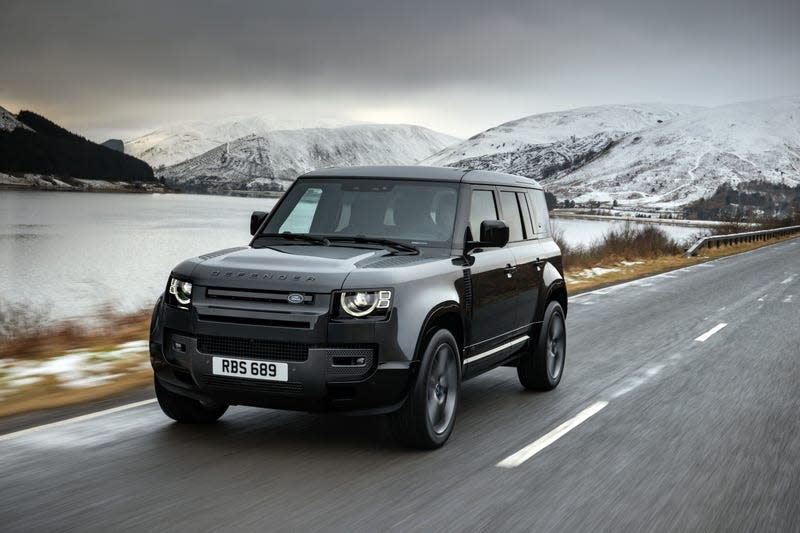 A Land Rover Defender 110 V8 drives in front of a frosty looking lake.