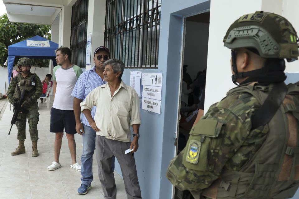 Voters line up at a polling station during referendum proposed by President Daniel Noboa to endorse new security measures aimed at cracking down on criminal gangs fueling escalating violence, in Olon, Ecuador, Sunday, April 21, 2024. (AP Photo/Cesar Munoz)