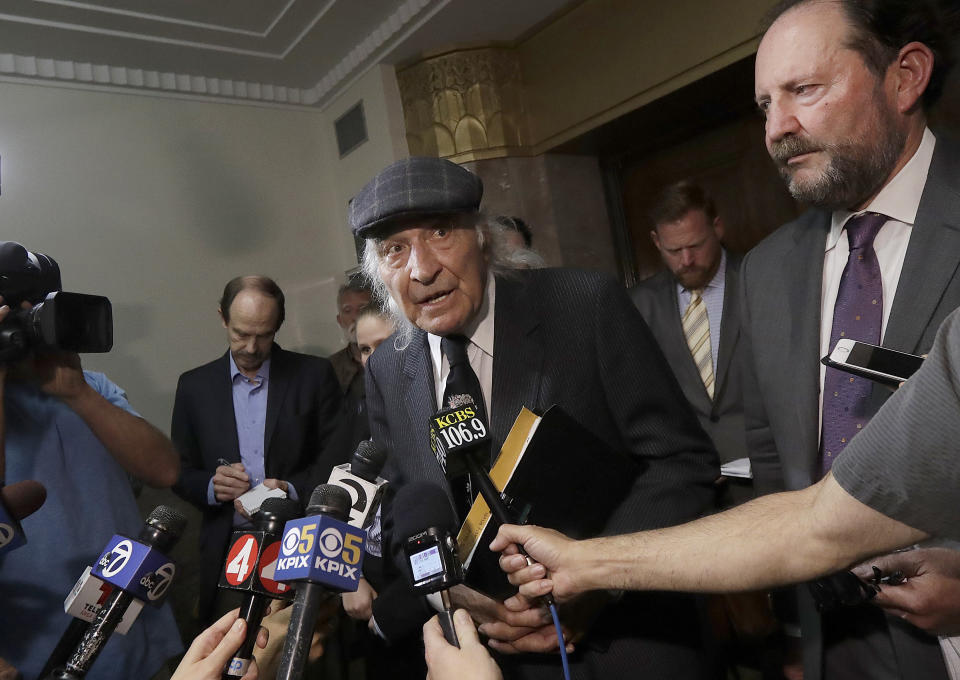 FILE - In this July 3, 2018, file photo, attorneys Tony Serra, center, and Brian Getz, right, representing Derick Almena, speak to reporters at a courthouse in Oakland, Calif. More than two years after 36 people died in the fire, Almena and Max Harris, the two men who face charges of involuntary manslaughter, will stand trial on charges that they allegedly illegally converted the industrial building into an unlicensed entertainment venue and artist live-work space. (AP Photo/Jeff Chiu, File)