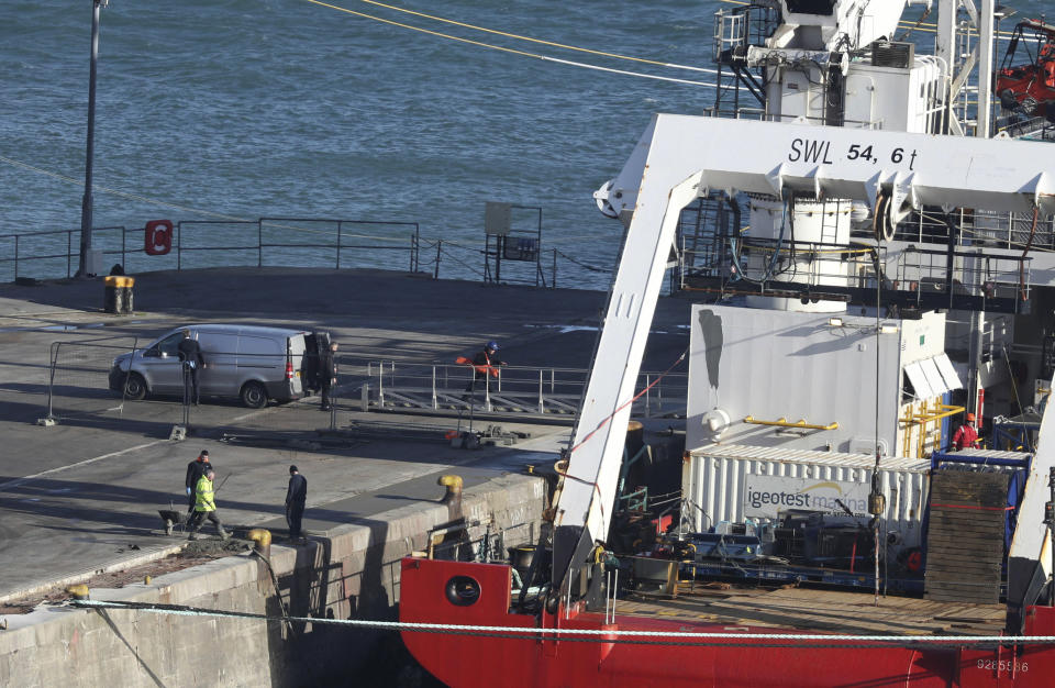 A van stands by the Geo Ocean III specialist search vessel docked in Portland, England, which is carrying a body recovered from the wreckage of the plane carrying Cardiff City footballer Emiliano Sala and pilot David Ibbotson, Thursday Feb. 7, 2019. The aircraft remains 67 metres underwater 21 miles off the coast of Guernsey in the English Channel as poor weather conditions stopped recovery efforts. (Steve Parsons/PA via AP)