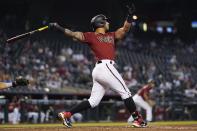 Arizona Diamondbacks' David Peralta watches the flight of his three-run home run against the Cincinnati Reds during the third inning of a baseball game Sunday, April 11, 2021, in Phoenix. (AP Photo/Ross D. Franklin)