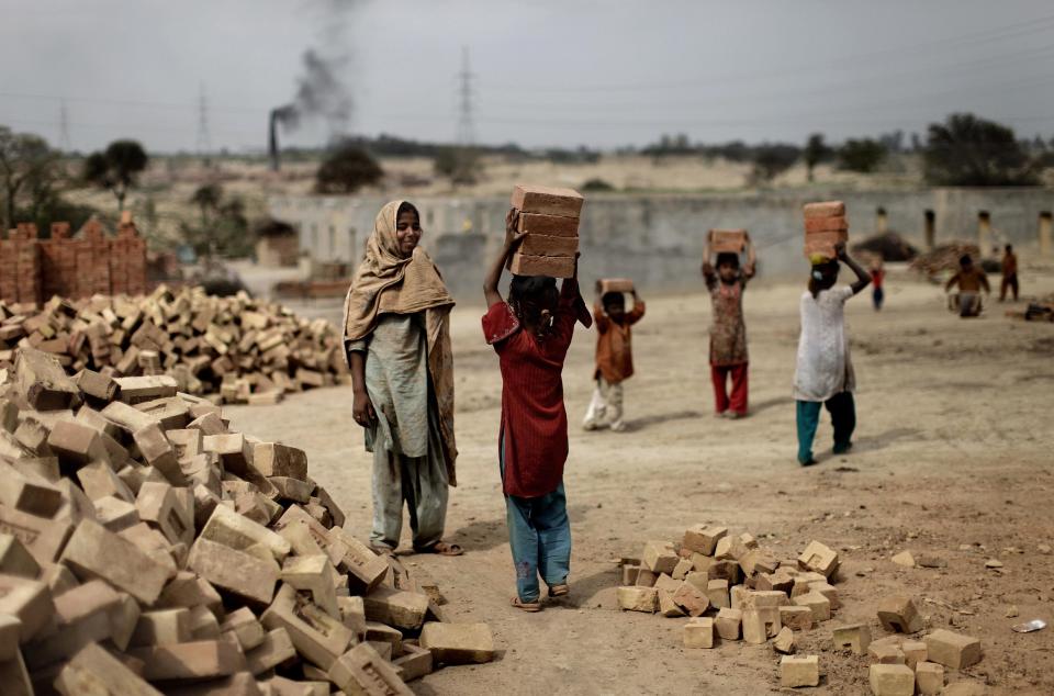 In this Wednesday, March 20, 2013, photo, Pakistani girls who forced to skip schools due to poverty, work in a brick factory, in Mandra, Pakistan. Wonder Woman and Supergirl now have a Pakistani counterpart in the pantheon of female superheroes _ one who shows a lot less skin. Meet Burka Avenger: a mild-mannered teacher with secret martial arts skills who uses a flowing black burka to hide her identity as she fights local thugs seeking to shut down the girls' school where she works. Sadly, it's a battle Pakistanis are all too familiar with in the real world. (AP Photo/Muhammed Muheisen)