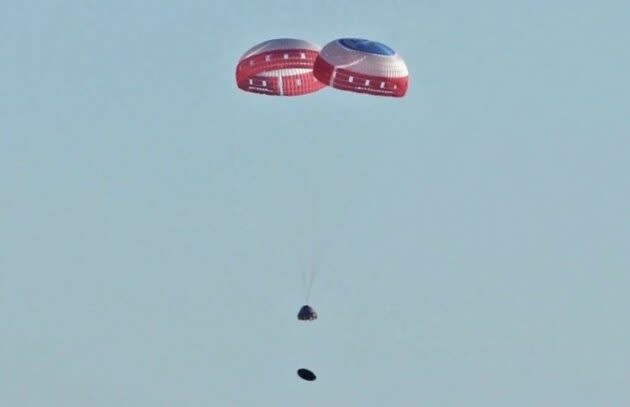 Boeing’s CST-100 Starliner space taxi descends on the end of two parachutes during this week’s pad abort test. The Starliner’s heat shield can be seen falling away beneath the craft. (Boeing Photo)