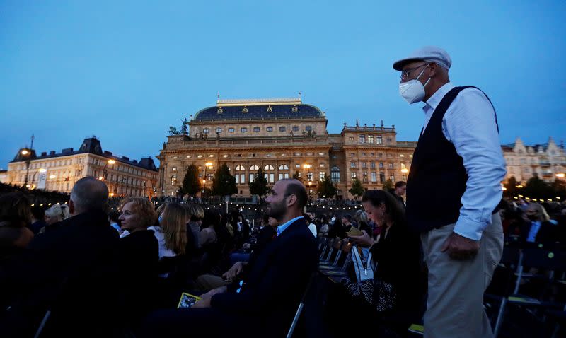 People watch a classical concert on a floating stage in Prague