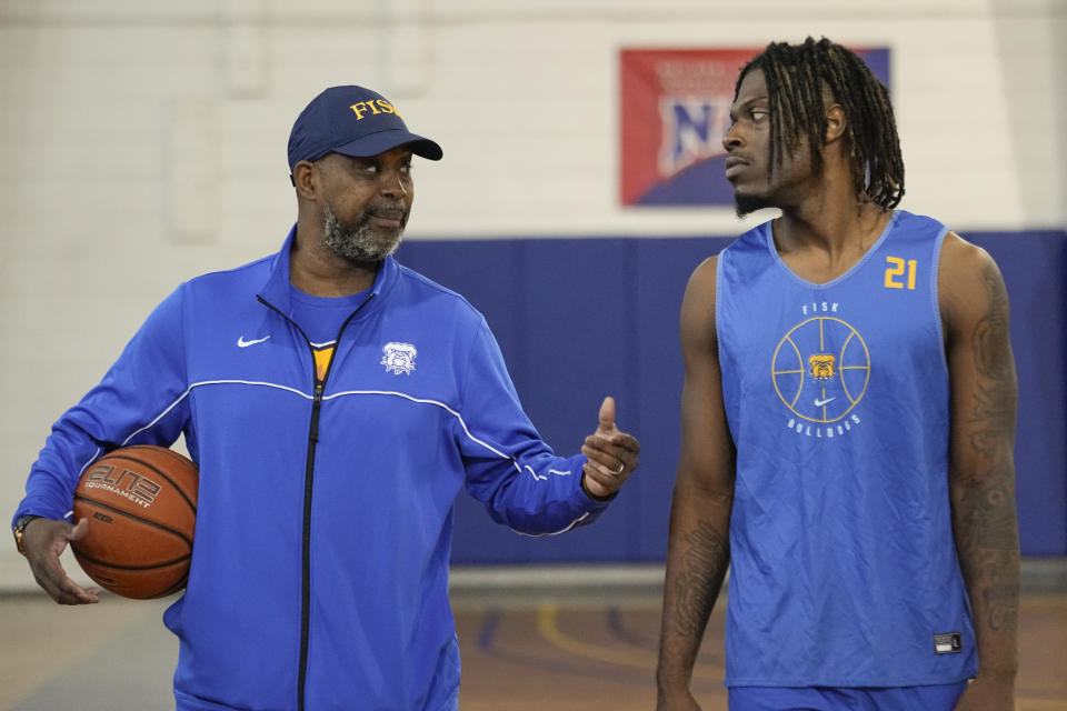 Fisk University basketball head coach Kenny Anderson, left, talks to Jeremiah Armstead on the basketball court Wednesday, March 6, 2024, in Nashville, Tenn. The formerly homeless Armstead will receive the U.S. Basketball Writers Association 2024 Perry Wallace Most Courageous award at the NCAA Final Four basketball tournament. (AP Photo/George Walker IV)