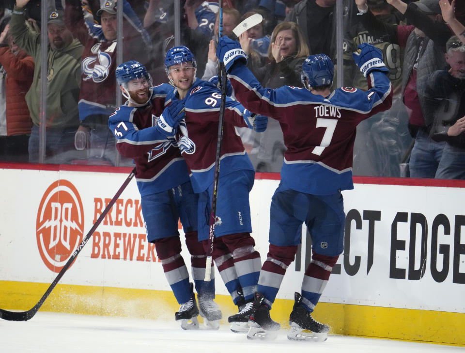 Colorado Avalanche right wing Mikko Rantanen, center, celebrates after scoring the winning goal with left wing J.T. Compher, back, and defenseman Devon Toews in overtime of an NHL hockey game against the Edmonton Oilers, Sunday, Feb. 19, 2023, in Denver. (AP Photo/David Zalubowski)