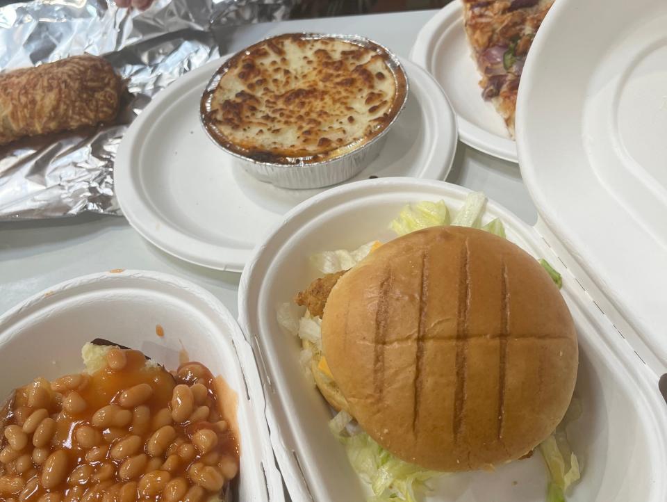 Chicken sandwich, baked beans, and cottage pie on table at Costco food court