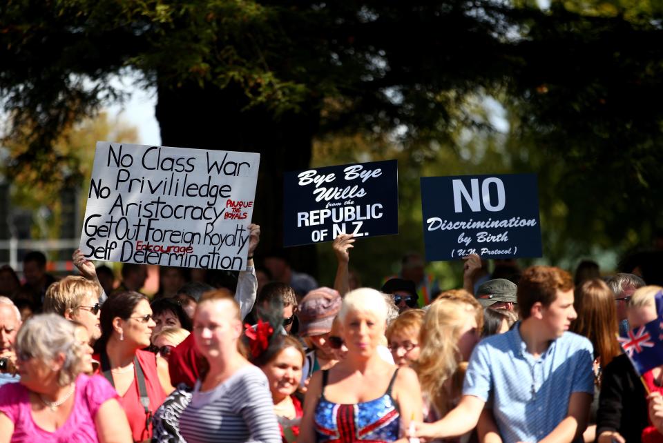 Protesters hold signs during Prince William and Kate Middleton's tour of New Zealand