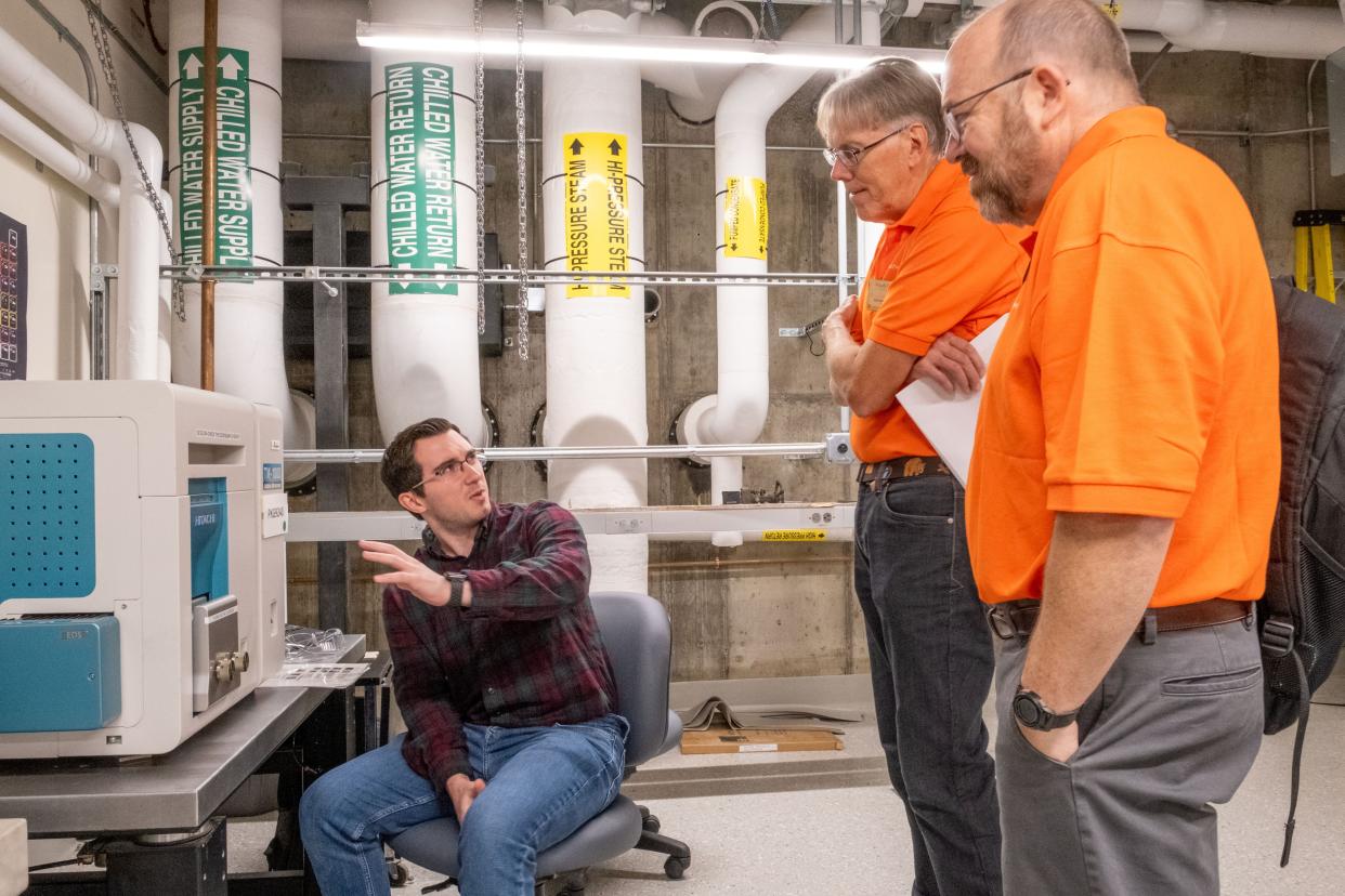 UVM electrical engineering student Jacob Allen discusses the device characterization teaching lab's wafer prober with GlobalFoundries staff Woody Bowe (center) and Scott Johnson, senior director of technology development.