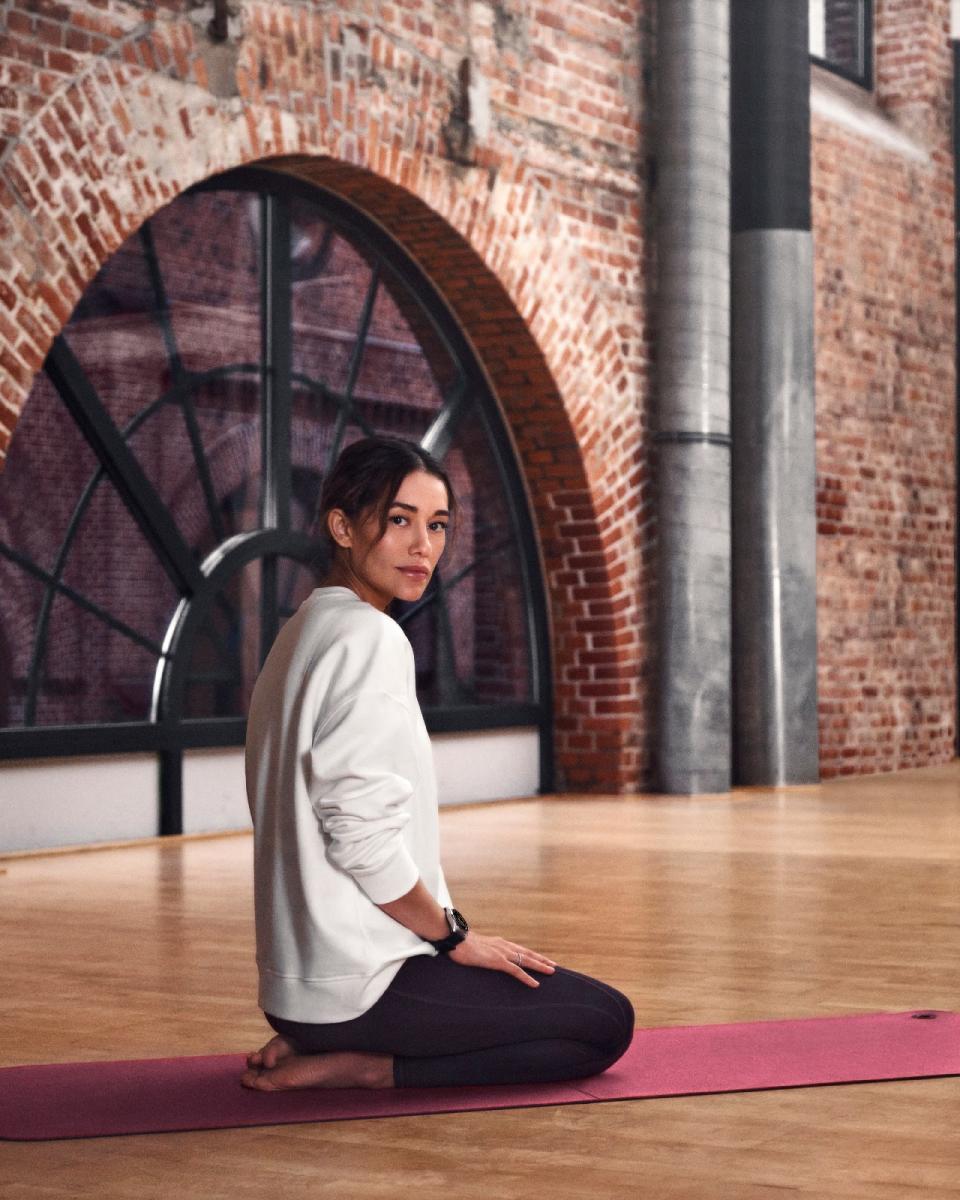 <p>Montblanc Summit Lite. A woman wearing the Summit Lite on her left wrist sits on a yoga mat with her legs bent below her in a loft.</p>
