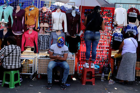 A migrant from Venezuela, sells clothing at Gamarra textile cluster in Lima's district of La Victoria in Lima, Peru, May 10, 2018. REUTERS/Guadalupe Pardo