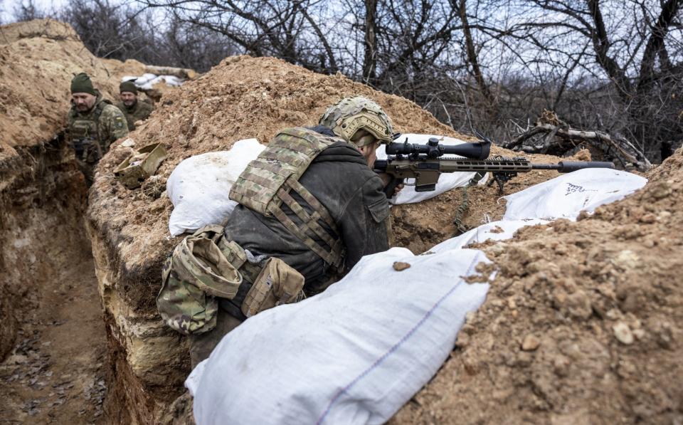 A Ukrainian soldier takes aim in a frontline trench near Bakhmut - John Moore/Getty Images Europe