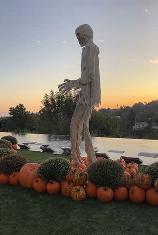 <p>Chrissy Teigen/Instagram</p> The skeleton towered over a patch of pumpkins