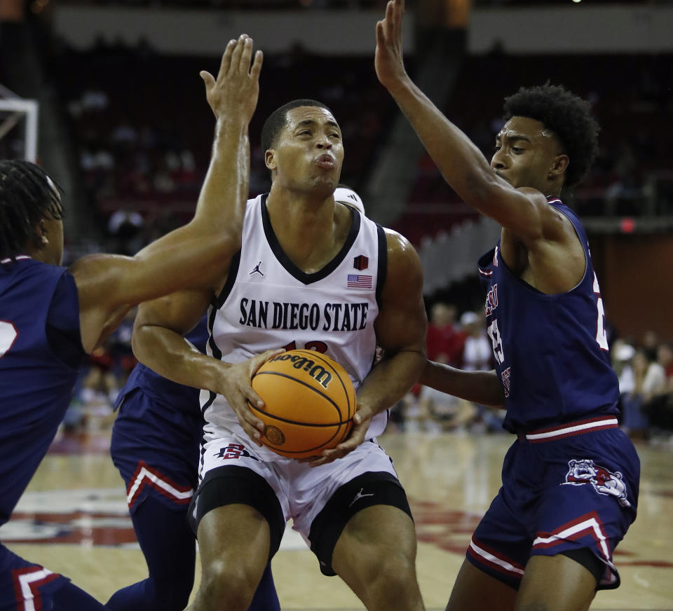 San Diego State forward Jaedon LeDee looks for a shot next to Fresno State's Leo Colimerio, right, during the first half of an NCAA college basketball game in Fresno, Calif., Saturday, Feb. 24, 2024. (AP Photo/Gary Kazanjian)