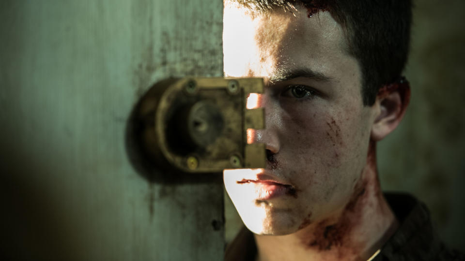 Dylan's bloody character looking from behind a door