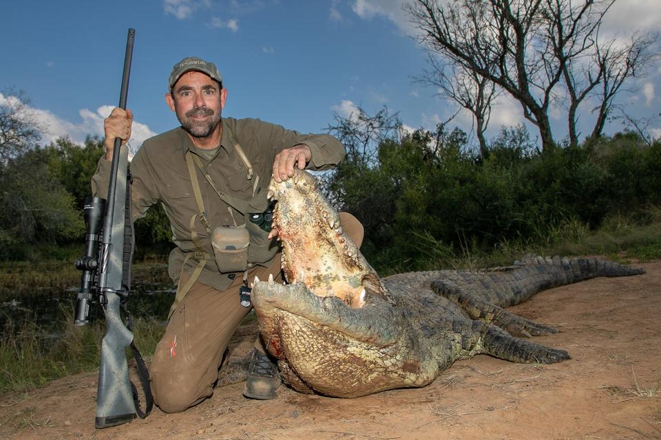 hunter holds croc mouth open