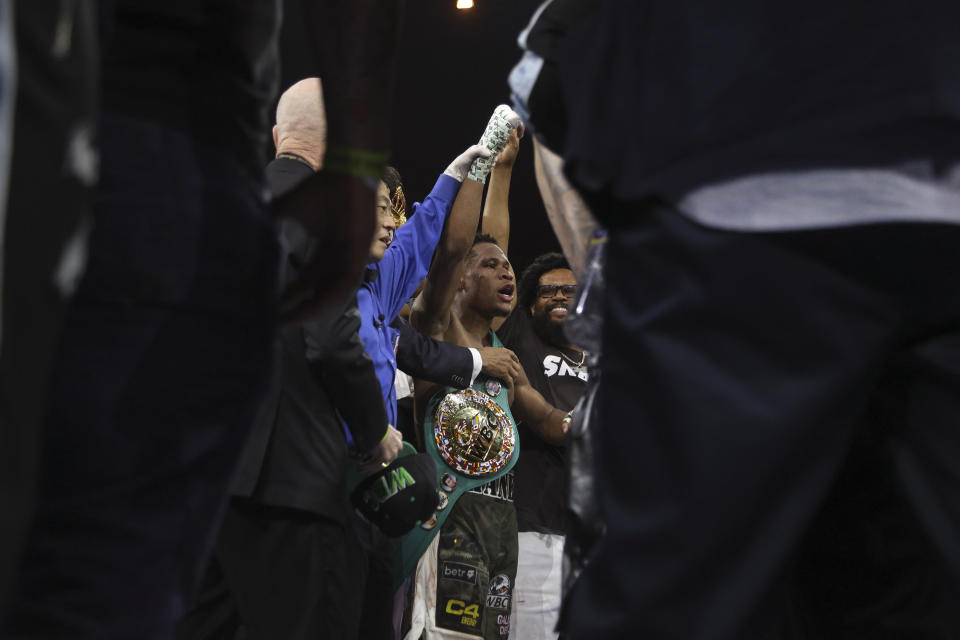 United States' Devin Haney, centre, raises his hand after fighting George Kambosos Jr. of Australia as Haney defends his undisputed lightweight boxing title in Melbourne, Sunday, Oct. 16, 2022. (AP Photo/Hamish Blair)