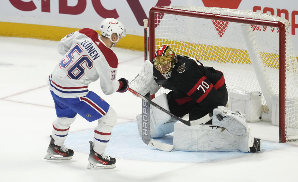Ottawa Senators goaltender Joonas Korpisalo, right, makes a save against Montreal Canadiens right wing Jesse Ylonen, left, during a shootout in NHL hockey game action in Ottawa, Ontario, Saturday, April 13, 2024. (Adrian Wyld/The Canadian Press via AP)