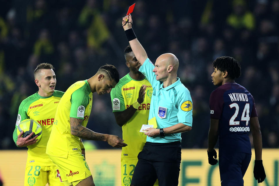 Referee Tony Chapron shows a red card to Nantes defender Diego Carlos after kicking him