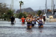 <p>People walk on a flooded street in the aftermath of Hurricane Maria in San Juan, Puerto Rico on Sept. 22, 2017. (Photo: Ricardo Arduengo/AFP/Getty Images) </p>