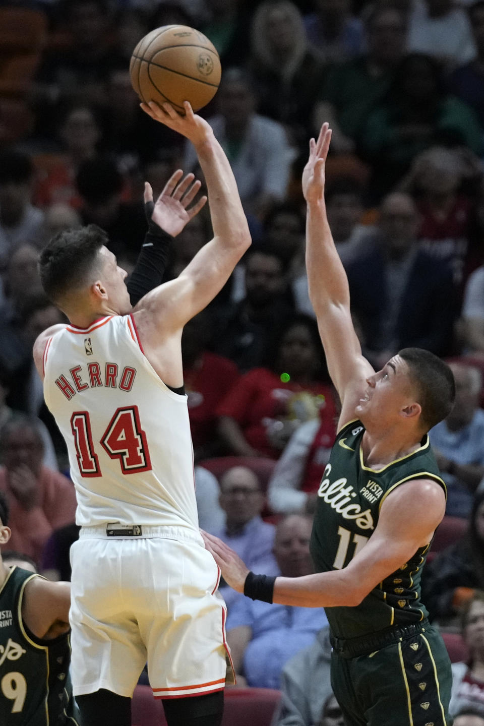 Miami Heat guard Tyler Herro (14) takes a shot against Boston Celtics guard Payton Pritchard (11) during the first half of an NBA basketball game, Tuesday, Jan. 24, 2023, in Miami. (AP Photo/Wilfredo Lee)