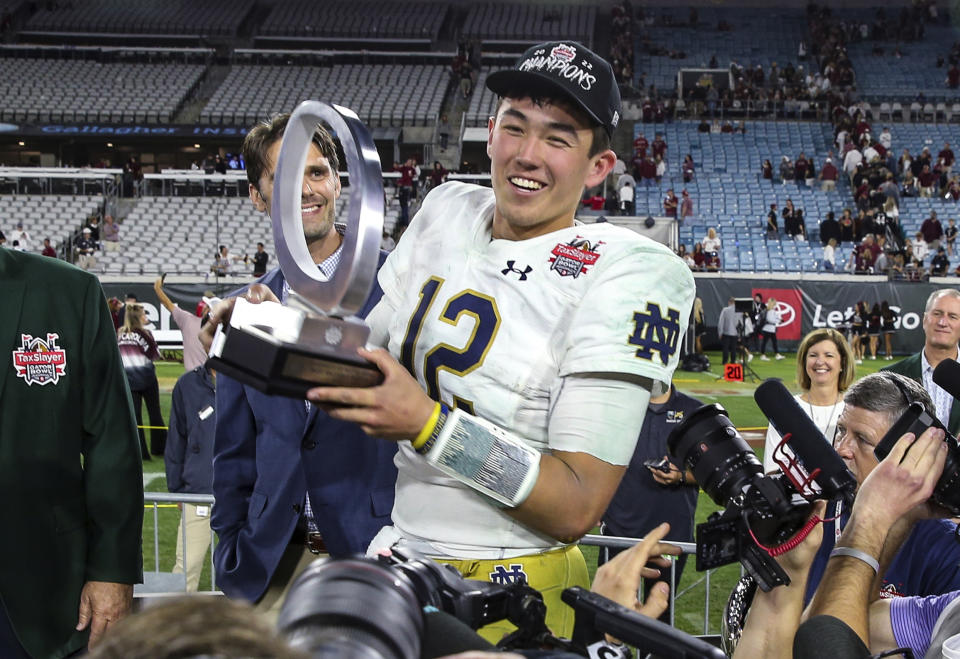 Notre Dame quarterback Tyler Buchner (12) holds with the MVP trophy after the team's Gator Bowl NCAA college football game against South Carolina on Friday, Dec. 30, 2022, in Jacksonville, Fla. Notre Dame won 45-38. (AP Photo/Gary McCullough)