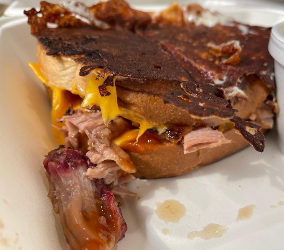 The king brisket grilled cheese is a slow-smoked brisket and barbecue sauce grilled cheese with melted cheese on top.