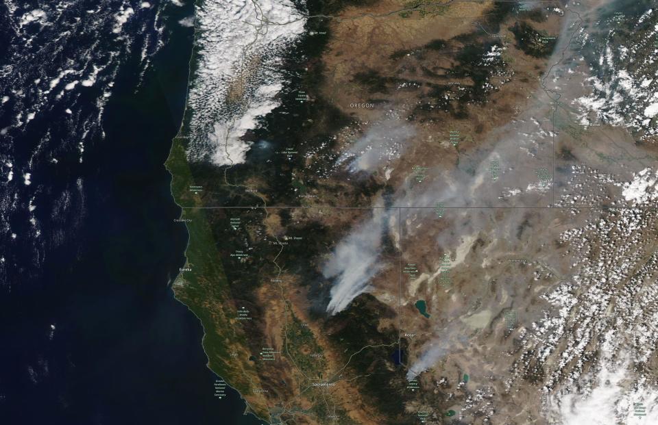 This satellite image provided by Satellite image ©2021 Maxar Technologies shows the wildfires in Northern California and Oregon on Wednesday, July 21, 2021. The Oregon fire, which was sparked by lightning, has ravaged the sparsely populated southern part of the state and had been expanding by up to 4 miles (6 kilometers) a day, pushed by strong winds and critically dry weather that turned trees and undergrowth into a tinderbox. (Satellite image ©2021 Maxar Technologies via AP)