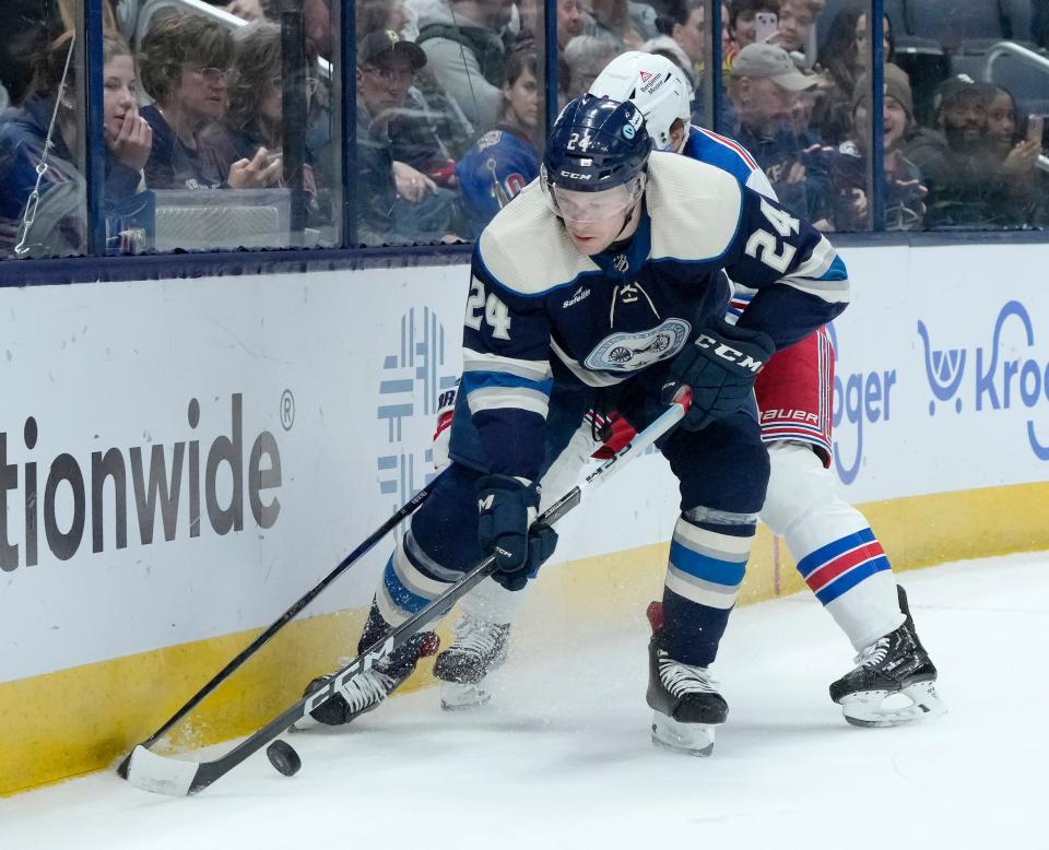 Feb. 25, 2024; Columbus, Ohio, USA; 
Columbus Blue Jackets right wing Mathieu Olivier (24) is defended by New York Rangers defenseman Jacob Trouba (8) during the third period of an NHL game at Nationwide Arena on Sunday.