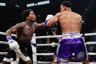 Gervonta Davis, left, punches Rolando Romero during the first round of a WBA lightweight championship boxing bout Sunday, May 29, 2022, in New York. Davis won in the sixth round. (AP Photo/Frank Franklin II)