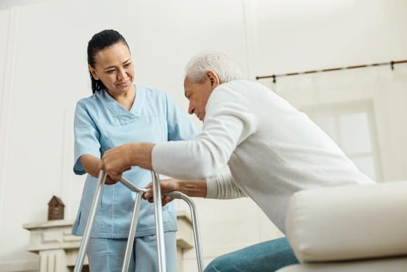 Nurse assisting an elderly patient in standing up.